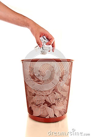 Hand throwing a paper into a wastebasket Stock Photo
