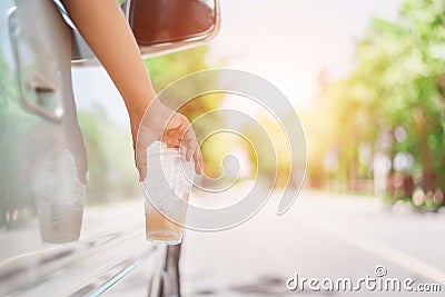 Hand throwing plastic bottle on the road Stock Photo