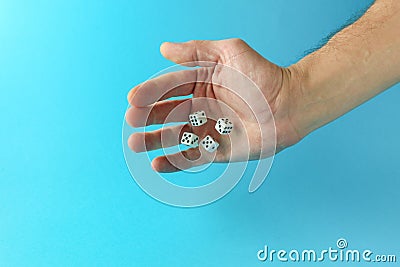 Hand throws dice on blue background Stock Photo