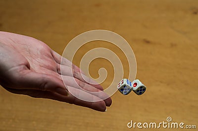 The hand throws dice to play a board game Stock Photo