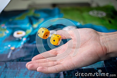 The hand throws yellow dice on the playing field. Luck and excitement. Concept Board games Stock Photo