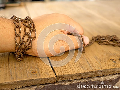 The hand are tied with rusty chain for not to escape Stock Photo