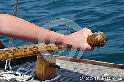 Hand on Tiller Steering a Schooner Sailboat Stock Photo