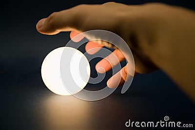 Hand touching a bright ball Stock Photo