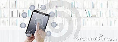Hand touching digital tablet with icons isolated in library background Stock Photo