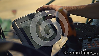 Hand touching harvester monitor closeup. Tractor driver working grain field Stock Photo