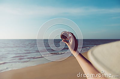 Hand traveler woman holding compass at the beach,Navigation for travel,Close up Stock Photo