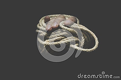 Hand trying to free itself from a rope that is tightening it, concept of freedom Stock Photo