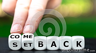 Hand tuns dice and changes the expression `setback` to `comeback`. Stock Photo