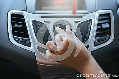 Hand turning on car radio system Stock Photo