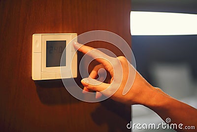 Hand turning on digital climate control Stock Photo