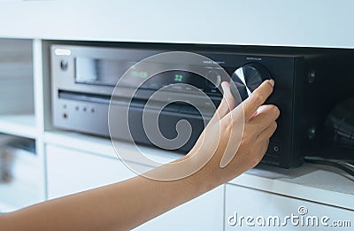 Hand turning on Home-theater amplifier Stock Photo