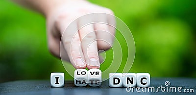 Hand turns dice and changea the expression `I hate DNC` Democratic National Committee to `I love DNC`. Stock Photo