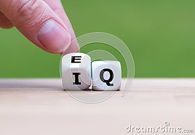 Hand turns a dice and changes the expression `IQ` Intelligence Quotient to `EQ` Emotional Intelligence/Quotient`. Stock Photo