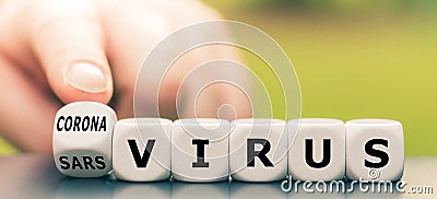 Hand turns a dice and changes the expression `sars virus` to `corona virus`. Stock Photo