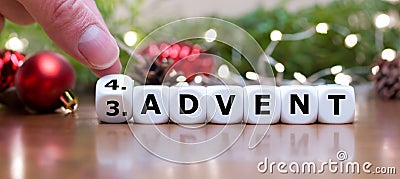 Hand turns dice and changes the expression 'third advent' to 'fourth advent'. Stock Photo