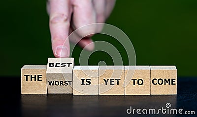 Hand turns dice and changes the expression 'the worst is yet to come' to 'the best is yet to come Stock Photo