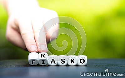 Hand turns dice and changes the German expression `Fiasko` fiasco to `Kasko` coverage. Stock Photo