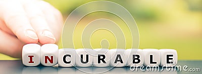 Hand turns dice and changes the word `incurable` to `curable`. Stock Photo