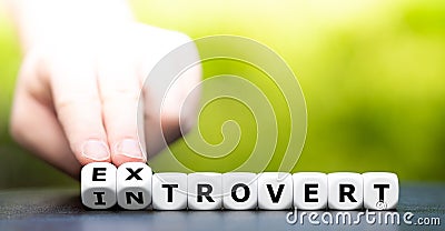 Hand turns dice and changes the word introvert to extrovert Stock Photo