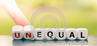 Hand turns dice and changes the word unequal to equal Stock Photo