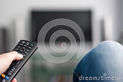 Hand with TV remote control Stock Photo