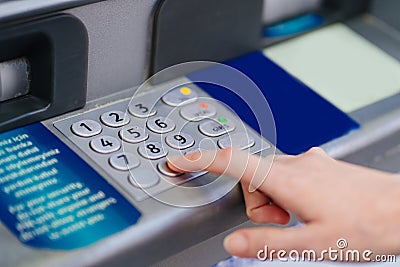 the hand types the pin code on the ATM keyboard. Stock Photo