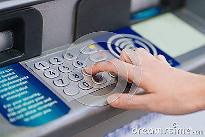 the hand types the pin code on the ATM keyboard. Stock Photo