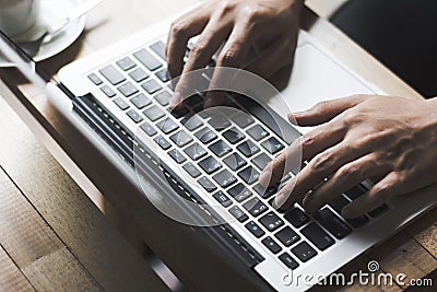 Hand typing keyboard on wooden table at coffee shop Stock Photo