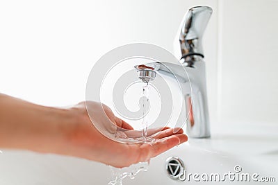 Hand under faucet with water stream Stock Photo