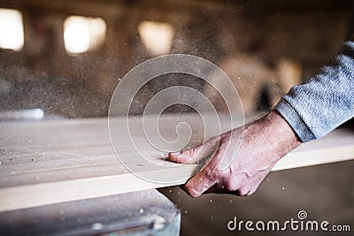 An unrecognizable man worker in the carpentry workshop, working with wood. Stock Photo