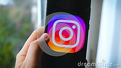 Hand use Instagram app symbol on smartphone Editorial Stock Photo