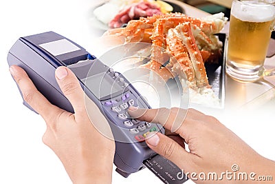 Hand Using Credit Card Machin with Food in Backgroun Stock Photo