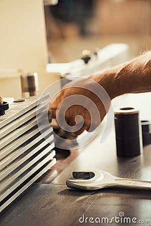 Hand using metal tool on self-operating wooden furniture Stock Photo