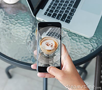 Hand using phone taking photo on coffee beverage Stock Photo