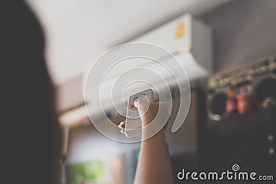 Hand using a remote control to activating air conditioning Stock Photo