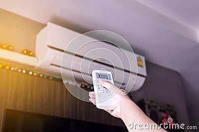 Hand using a remote control to activating air conditioning Stock Photo