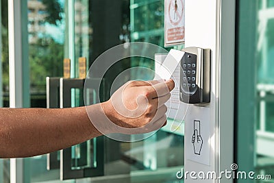 Hand using security key card scanning to open the door to entering private building. Home and building security system Stock Photo