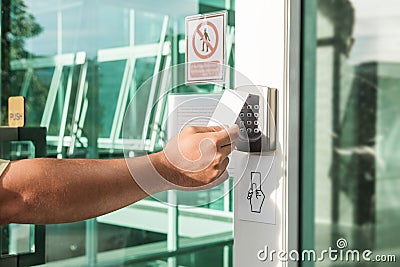 Hand using security key card scanning to open the door to entering private building. Home and building security system Stock Photo