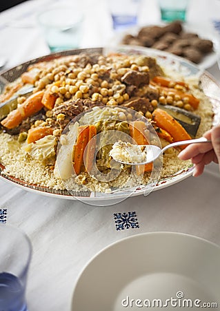 Couscous traditional moroccan with hand and spoon Stock Photo