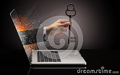 Hand with vintage huge key coming out of a laptop Stock Photo