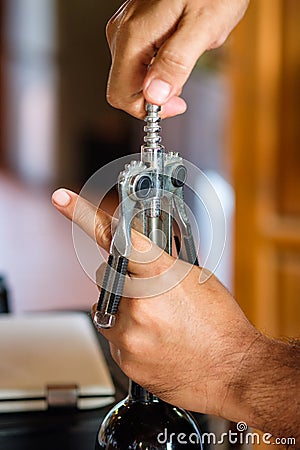 Hand waiter opening crok wine with lever opener Stock Photo