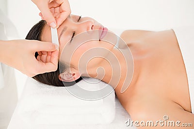 Hand waxing beautiful womans eyebrow Stock Photo