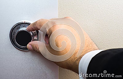 Hand wearing business suit turning safe dial lock Stock Photo