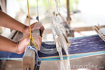 The hand of a weaver is woven with a hand-woven machine. Stock Photo