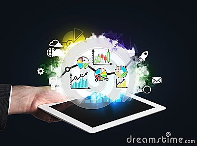 Hand which holds a tablet with digital charts and graphs. Stock Photo