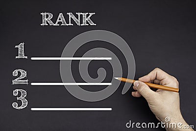 Hand with a white pencil writing: Rank blank list Stock Photo