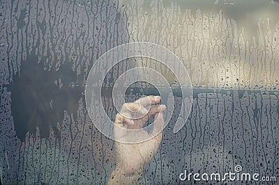 Hand of woman in the car window with rain drop. Loneliness and depression concept. Stock Photo