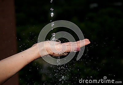 Hand of woman catching raindrops. Stock Photo