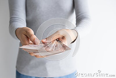 Hand of woman counting money on white background. Money baht of thailand in her hand Stock Photo